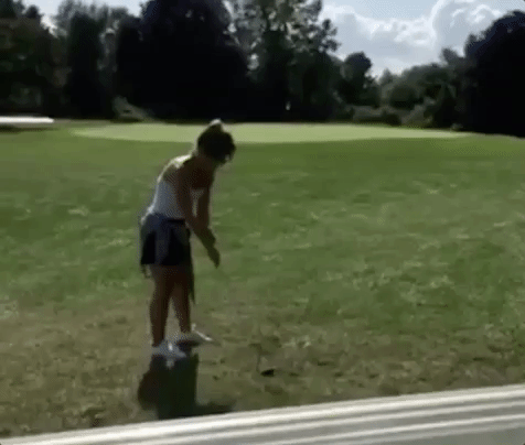 A person swinging a golf club, losing their balance, then falling.